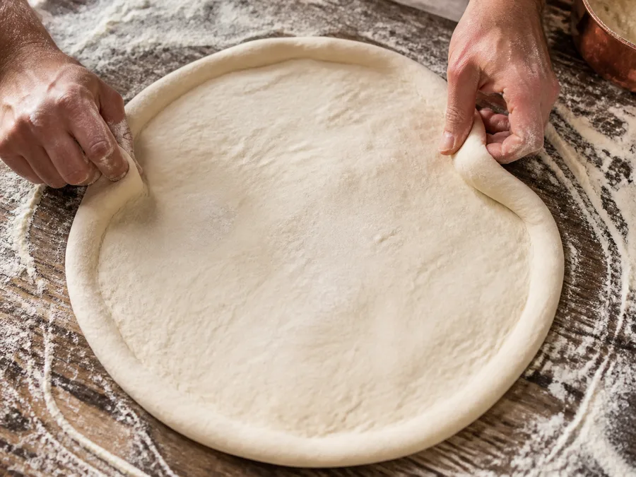 Пицца с начинкой: пепперони (острая салями) | Фото подпункта 7 | Viva Cucina Пицца с начинкой: пепперони (острая салями): фото процесса приготовления — выполните основной шаг "растянуть основу", не торопясь и сохраняя контроль над текстурой